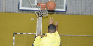 Fotografia ilustra jovem fazendo arremesso para cesta de basquete