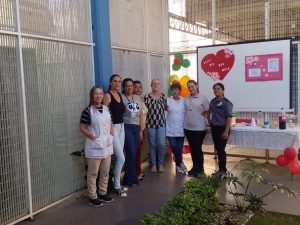 Foto mostra grupo de colaboradoras da Fundação CASA. Elas se abraçam. Ao fundo, está uma mesa com um café da manhã