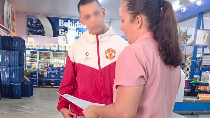 Jovem em medida socioeducativa interage com colaboradora de supermercado durante entrega de currículos.