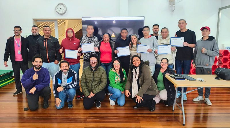 Grupo com adolescentes e servidores da Fundação CASA posa sorridente com certificados em sala de aula.