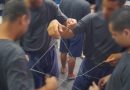 Fotografia retrata um grupo formado por quatro adolescentes que estão fazendo uma dinâmica de grupo com um fio. A dinâmica tem como objetivo gerar integração. Os jovens estão posicionados em forma de círculo e cada um deles segura uma parte do mesmo fio.